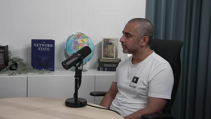 Balaji Srinivasan speaking into a microphone in the Network School studio